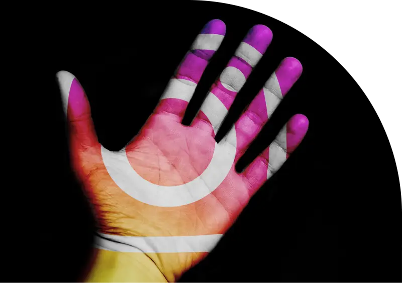 Hand with Instagram logo colors on a black background, symbolizing social media presence.
